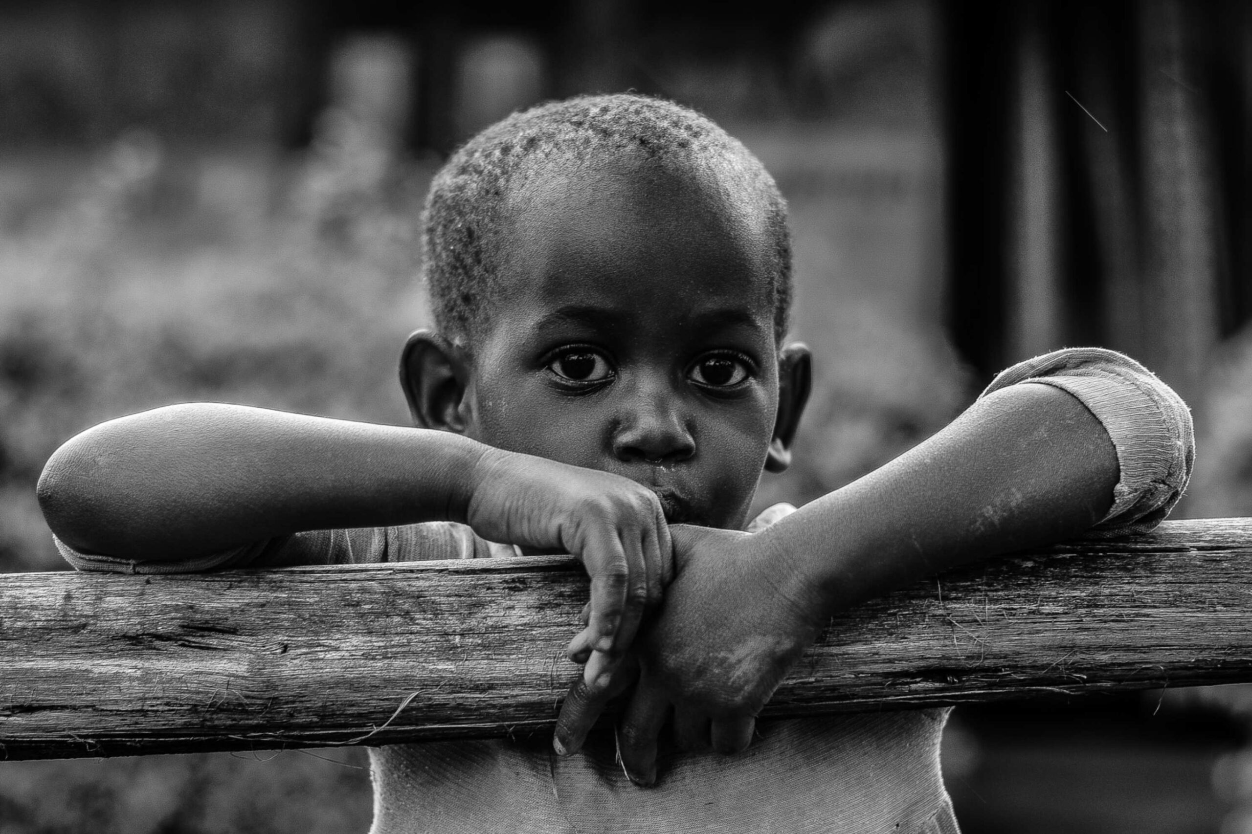 jpeg-optimizer_black-and-white-of-an-african-boy-leaning-on-a-tre-2024-11-26-16-01-52-utc